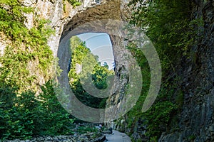 Visitors under the Rock Arch at Natural Bridge State Park, Virginia, USA